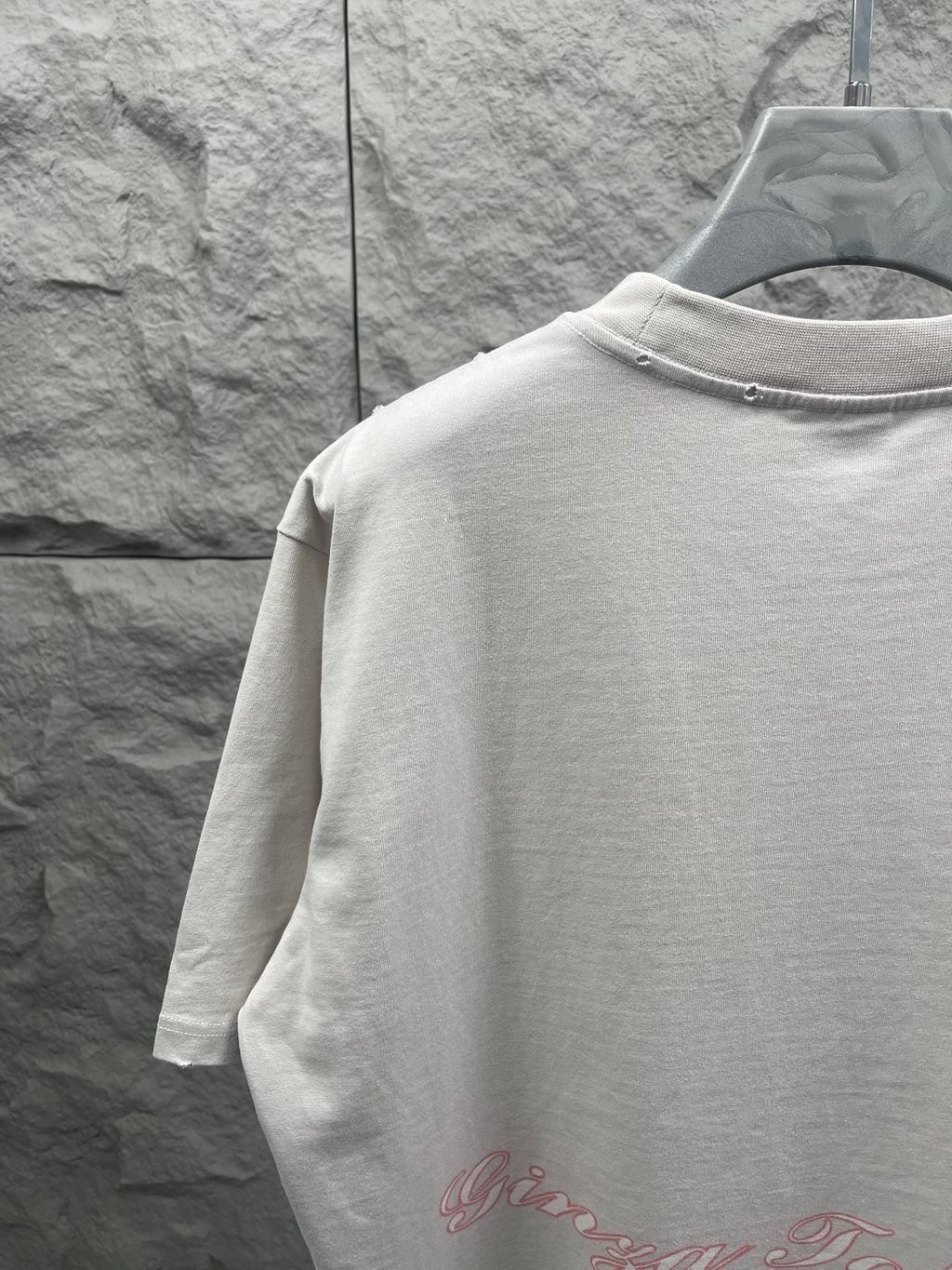 White T-shirt back neckline close-up with red script logo