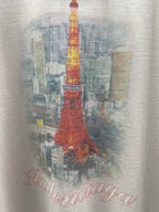 White T-shirt fabric close-up with red Eiffel Tower illustration and script logo
