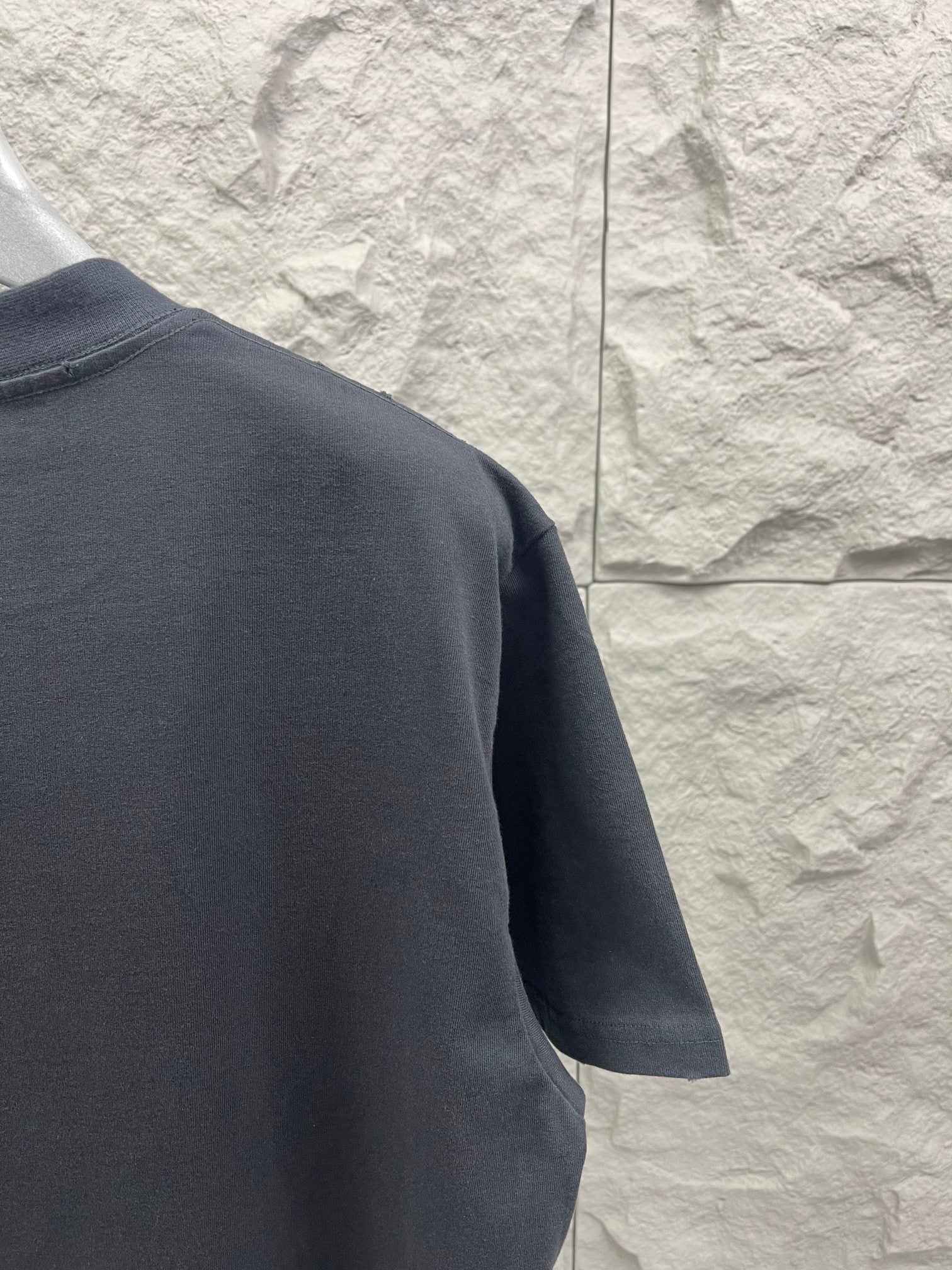Dark gray T-shirt sleeve and shoulder detail, no visible print on the side view