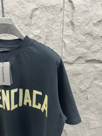 Dark Balenciaga logo T-shirt sleeve with partial yellow wordmark