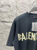 Balenciaga short-sleeve T-shirt, dark navy, yellow logo graphic and hanging size tag