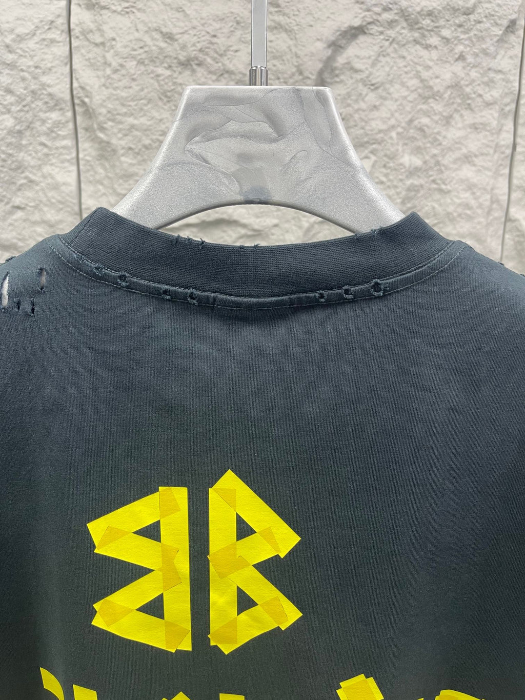 Dark graphic T-shirt neckline with yellow emblem print