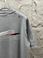 Grey T-shirt back with small distressed holes and partial logo print.