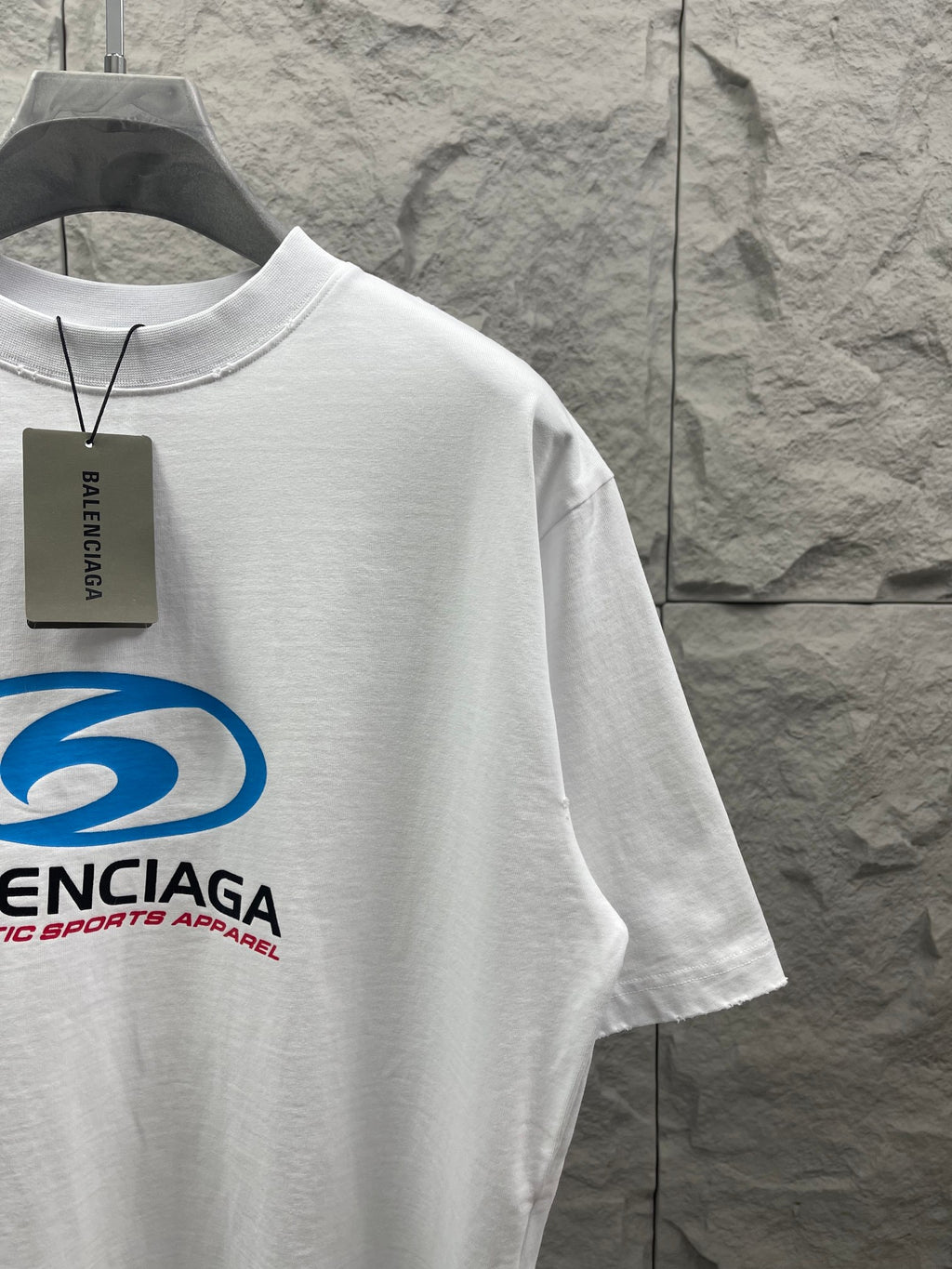White short-sleeve T-shirt with blue Balenciaga logo and hanging black tag