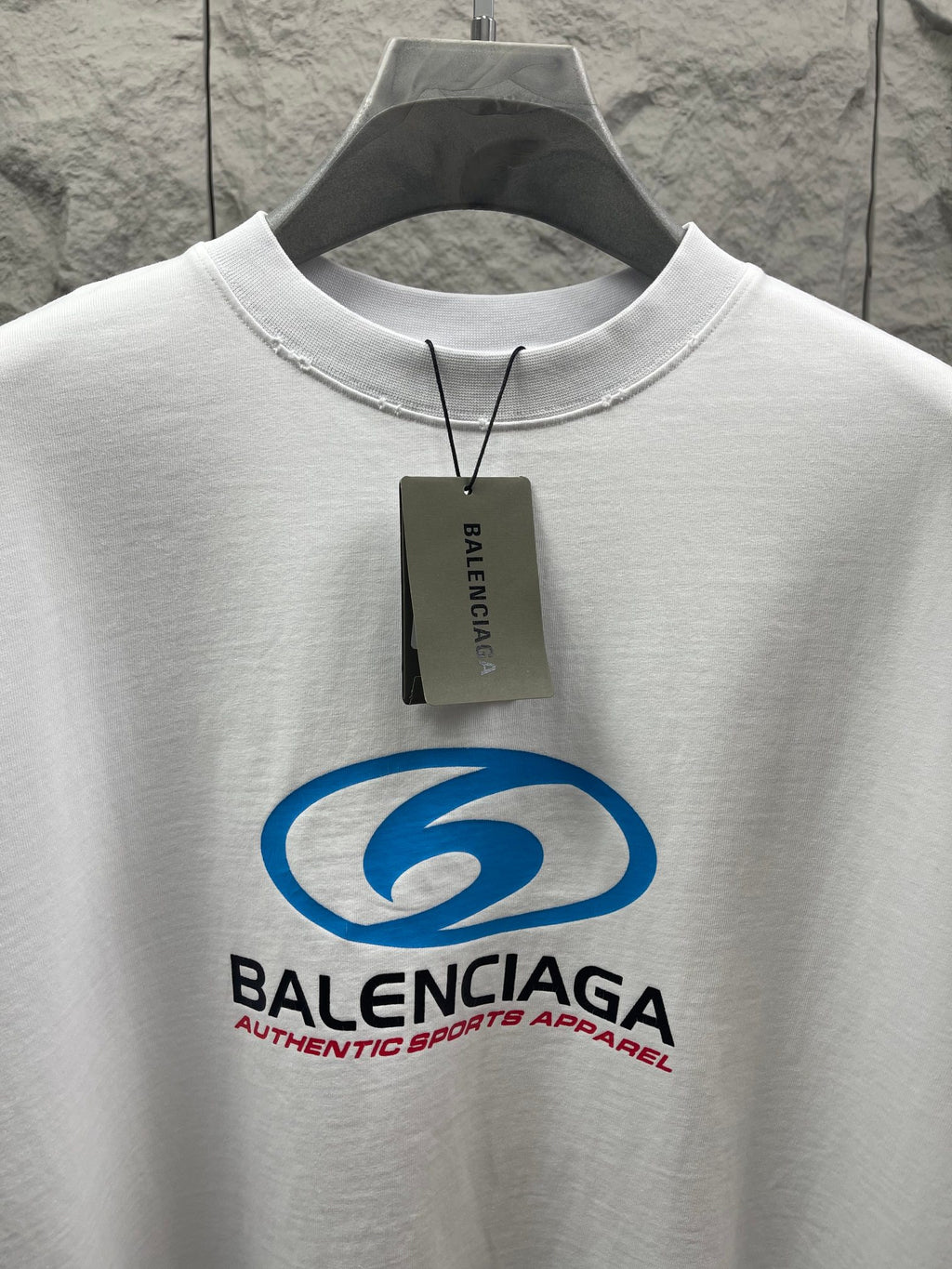 White short-sleeve T-shirt close-up with blue Balenciaga logo and neck tag