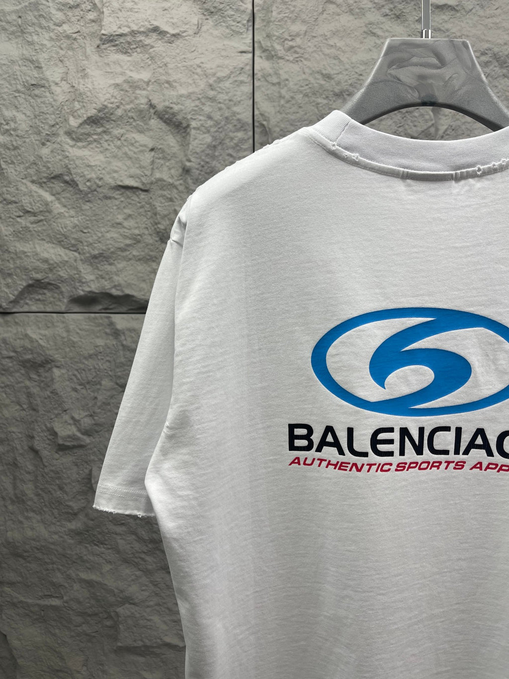 White short-sleeve T-shirt with partial blue Balenciaga logo and neck seam