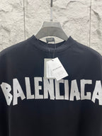 Black Balenciaga T-shirt with bold front BALENCIAGA logo, paper tag at collar