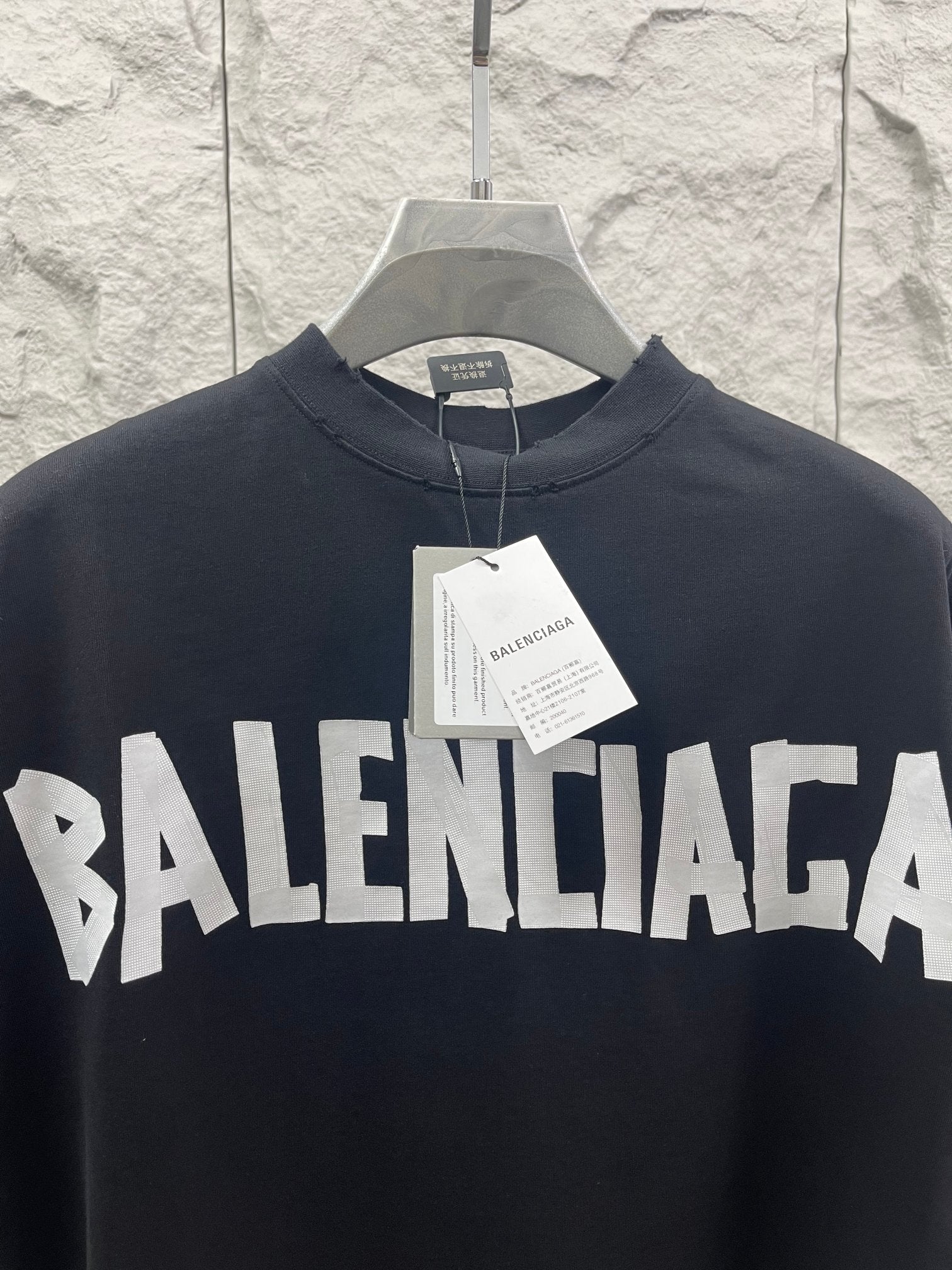 Black Balenciaga T-shirt with bold front BALENCIAGA logo, paper tag at collar