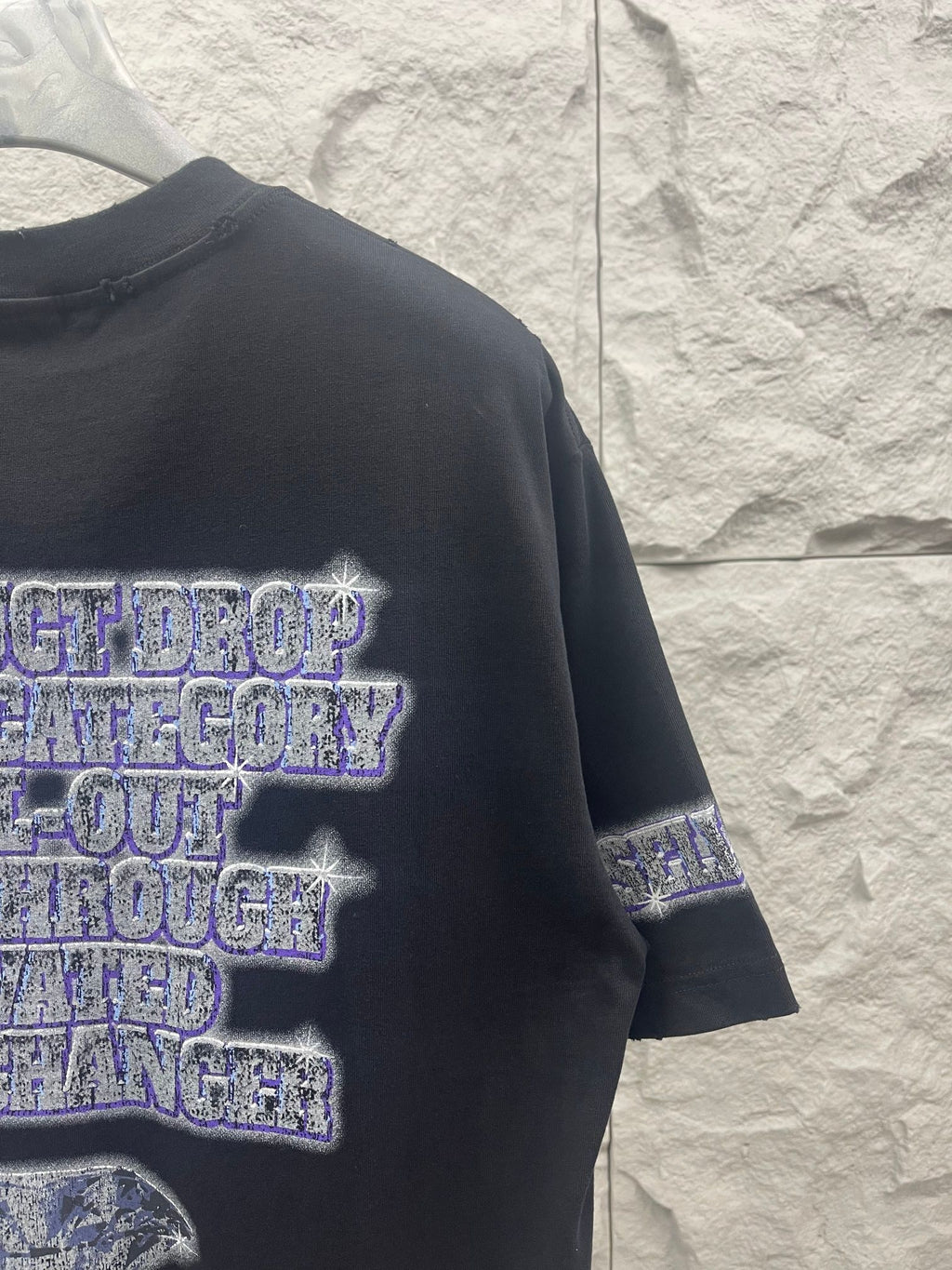 Balenciaga graphic T-shirt in dark color, side view showing layered text print