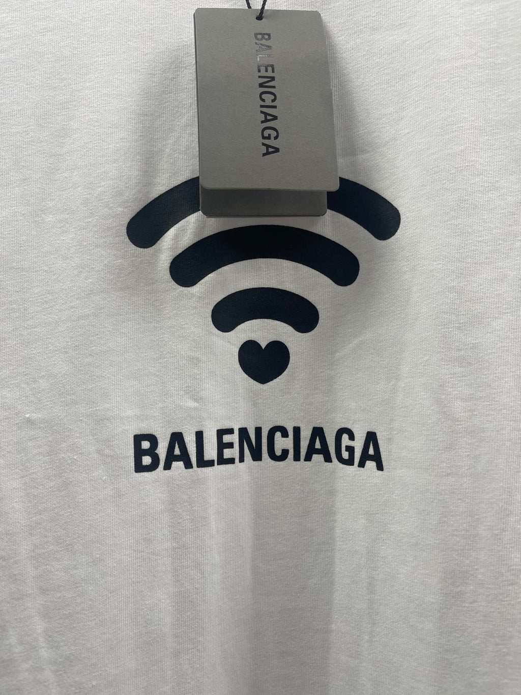 White Balenciaga T-shirt front with Wi‑Fi logo and hanging size tag