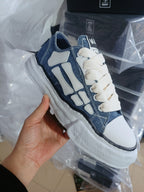 Denim low-top sneakers with white overlays, cream laces, thick rubber sole