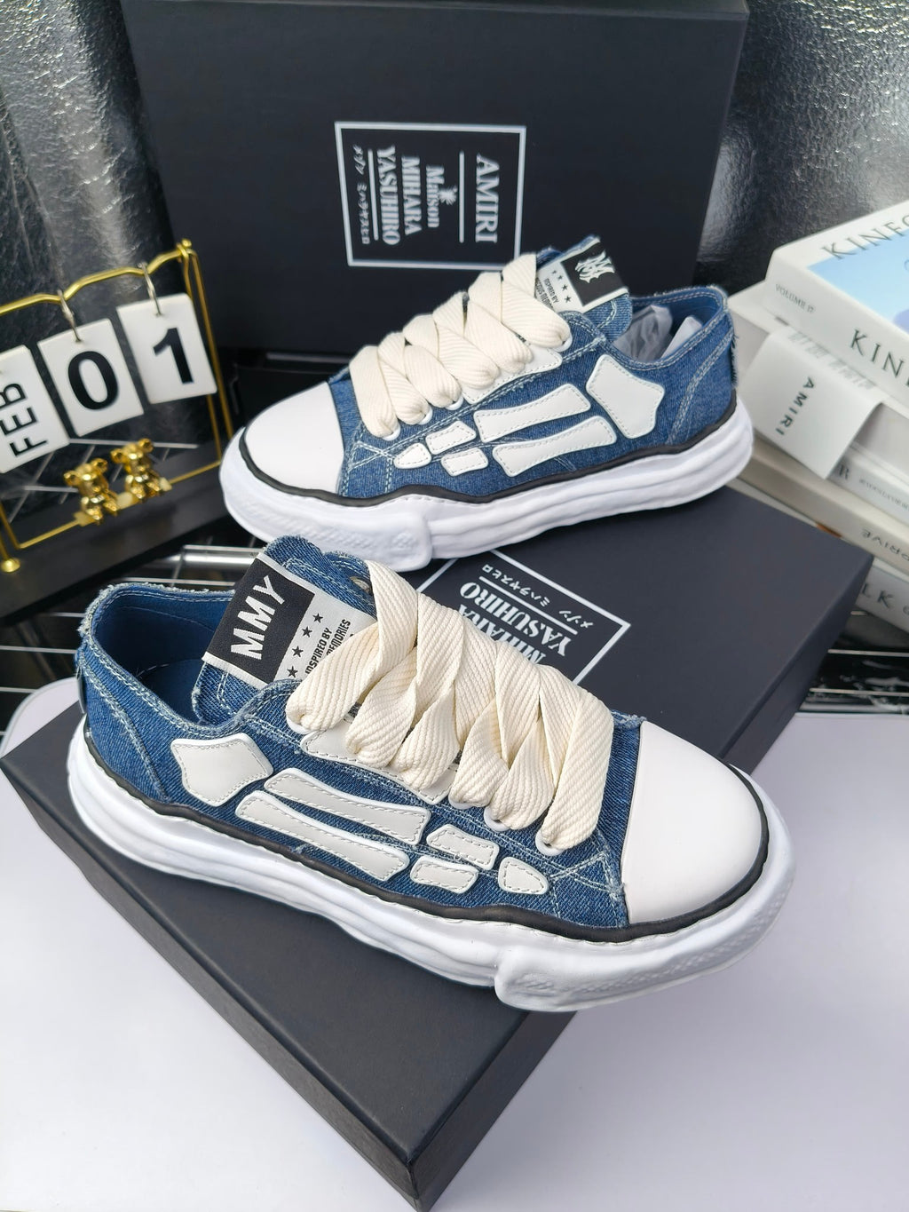 Blue denim low-top sneakers with white laces and white patterned side panels