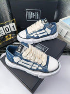 Blue denim low-top sneakers with white laces and white patterned side panels