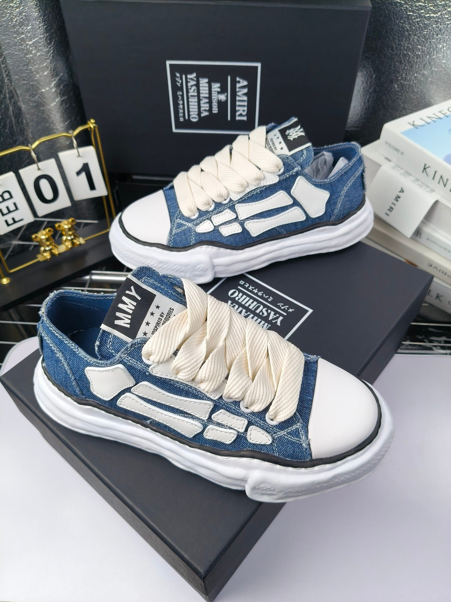 Blue denim low-top sneakers with white laces and white patterned side panels