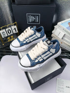 Blue denim low-top sneakers with white laces and white rubber soles, angled pair