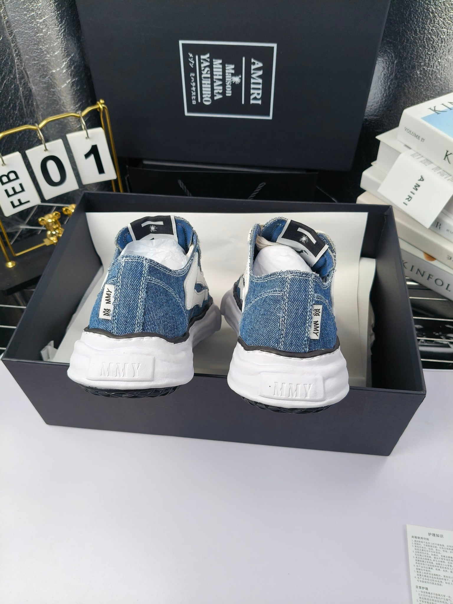 Blue denim low-top sneakers with white laces and white rubber heels, back view