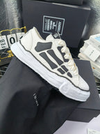 Low-top sneakers with white uppers, gray graphic panels, and white lace-up
