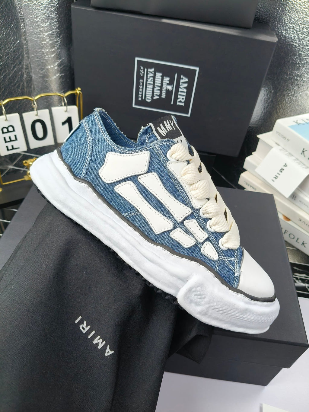 Pair of low-top sneakers with blue uppers, light blue graphics, and white laces
