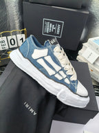 Pair of low-top sneakers with blue uppers, light blue graphics, and white laces