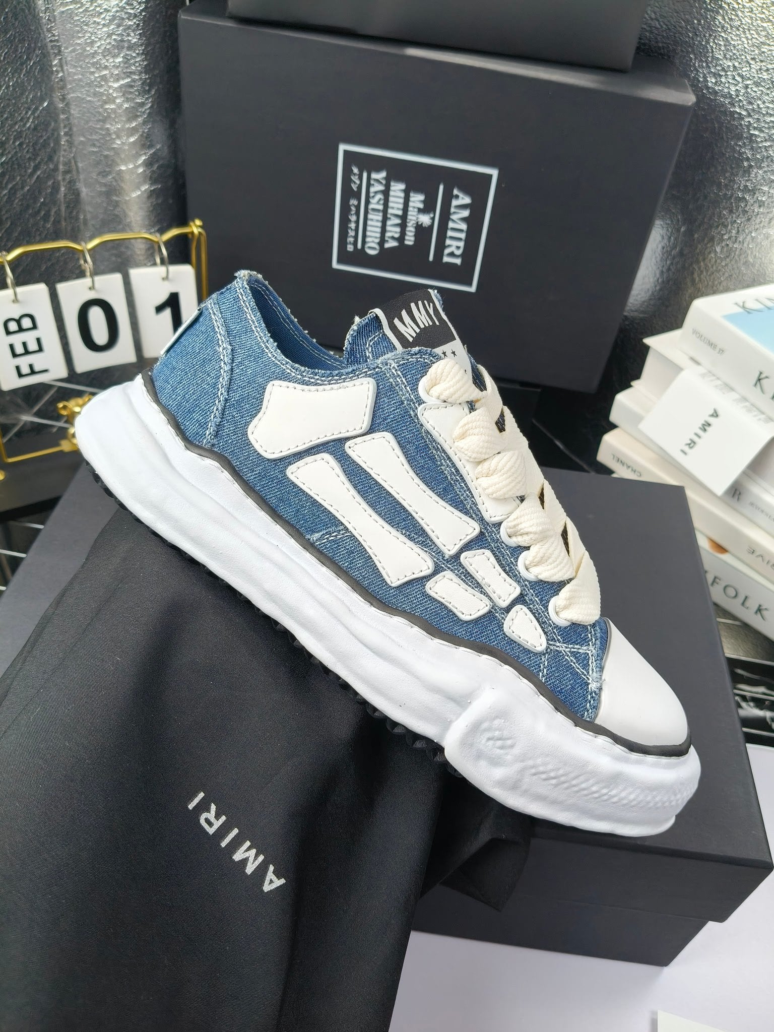 Pair of low-top sneakers with blue uppers, light blue graphics, and white laces
