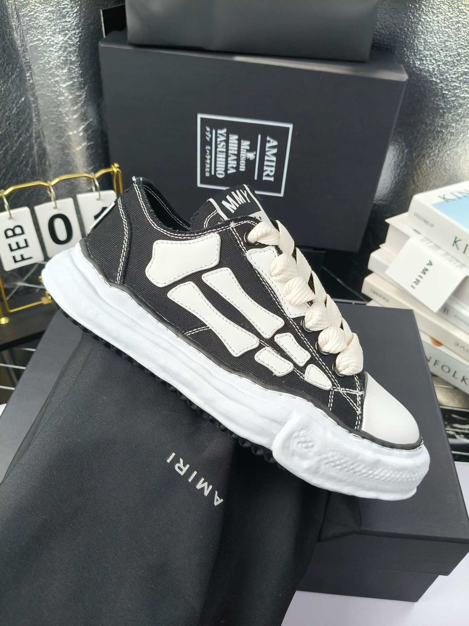 Pair of sneakers with black uppers, white graphic panels, and white lace-up