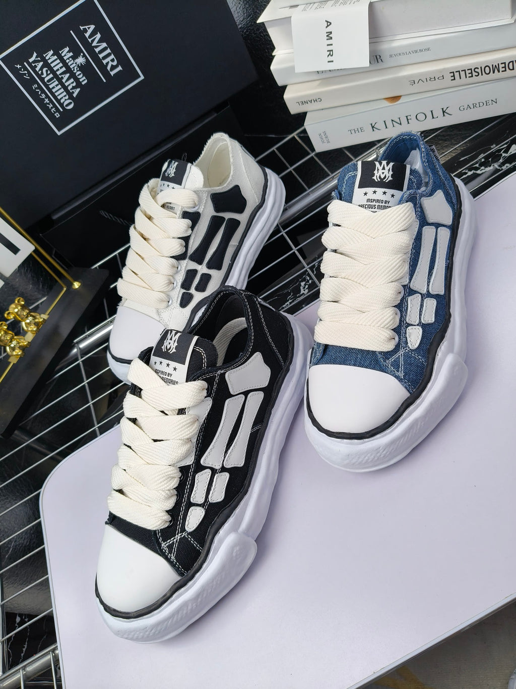 Two pairs of sneakers: white with black panels and blue denim with white laces