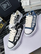 Two pairs of sneakers: white with black panels and blue denim with white laces