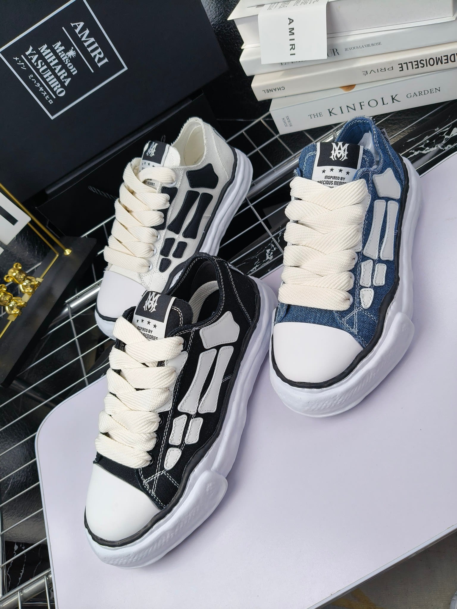 Two pairs of sneakers: white with black panels and blue denim with white laces