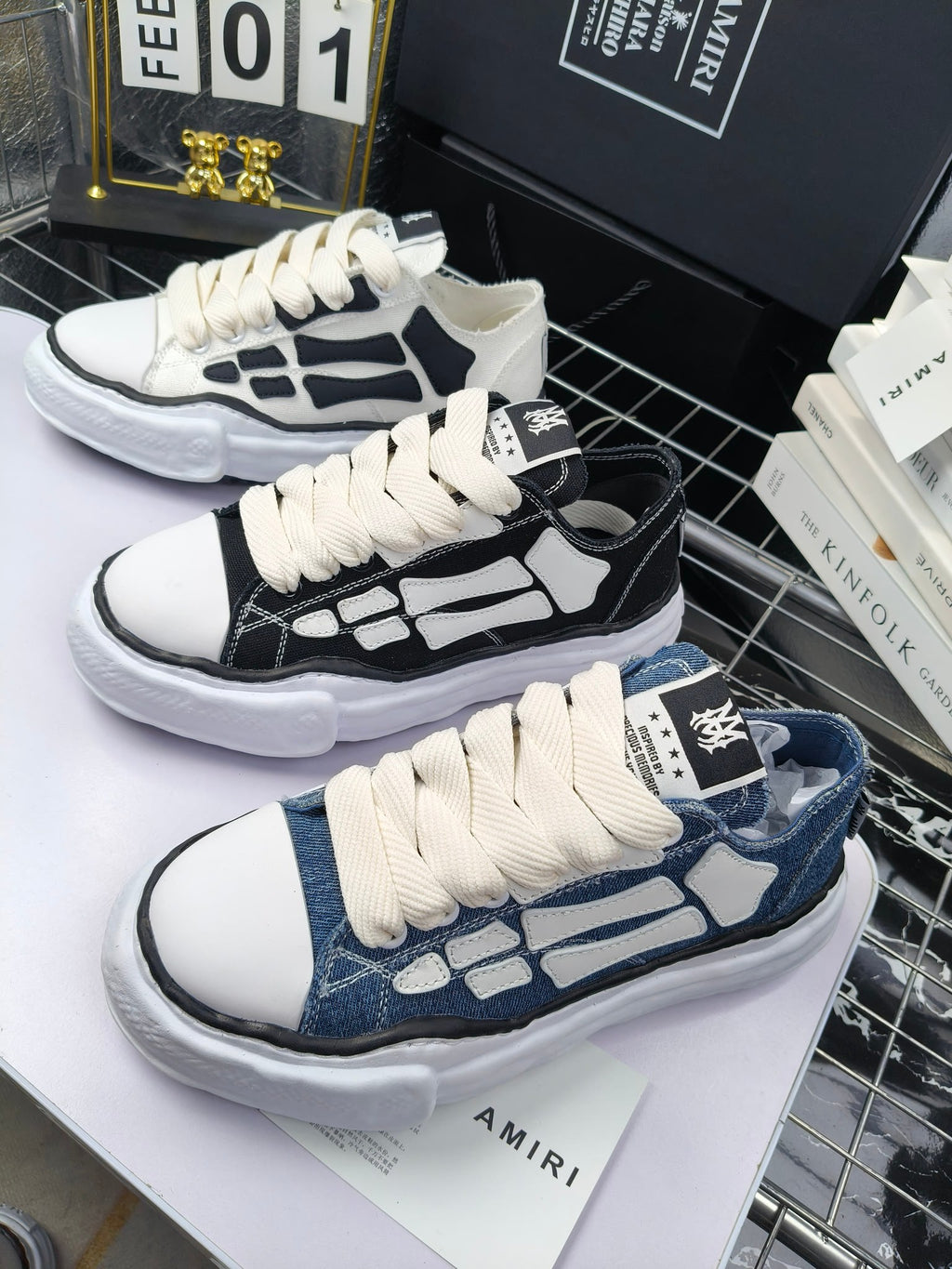 Pair of sneakers with white uppers, black graphic panels, and white laces