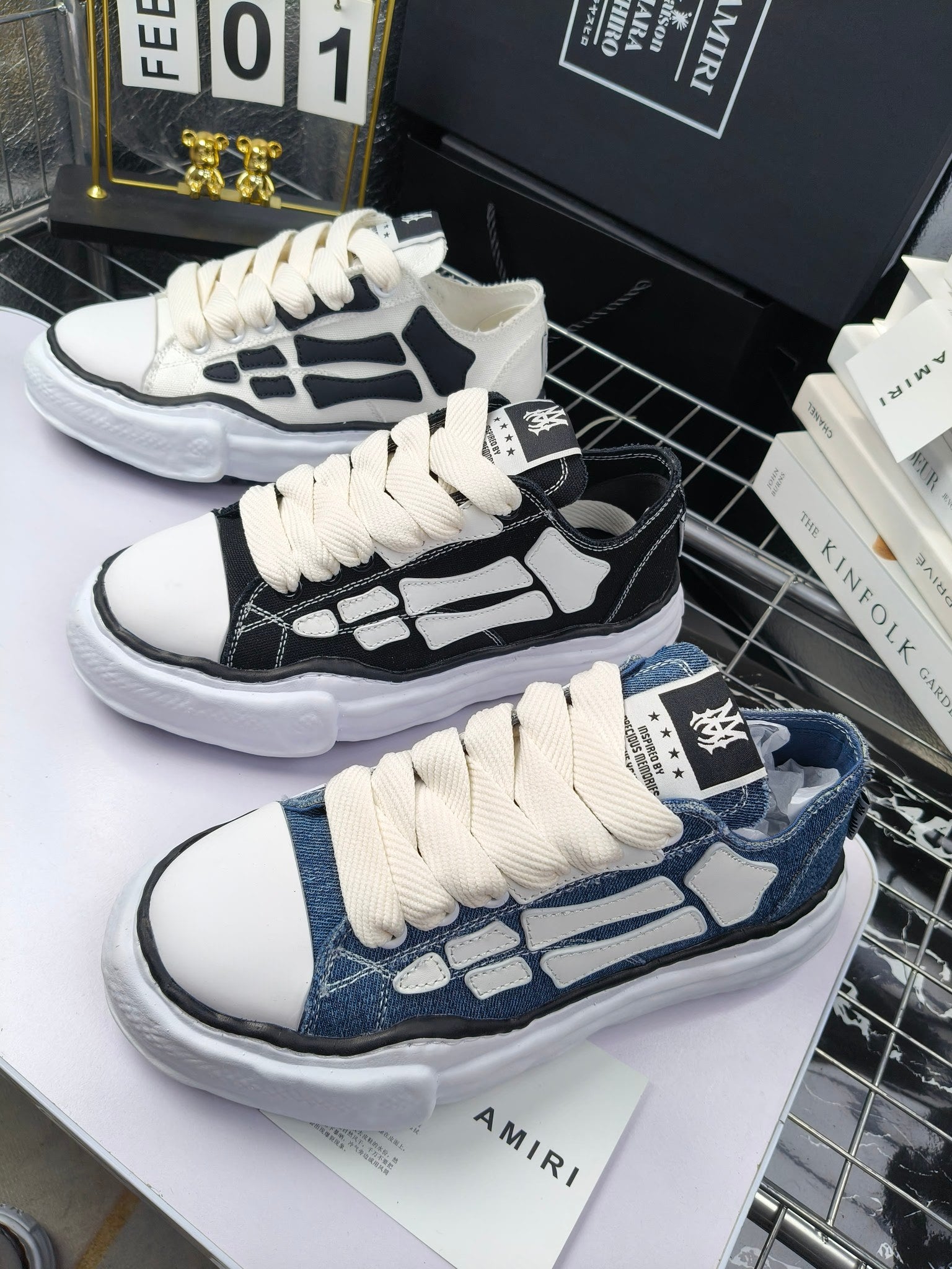 Pair of sneakers with white uppers, black graphic panels, and white laces