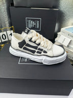 Pair of sneakers with white uppers, black graphic panels, and white lace-up