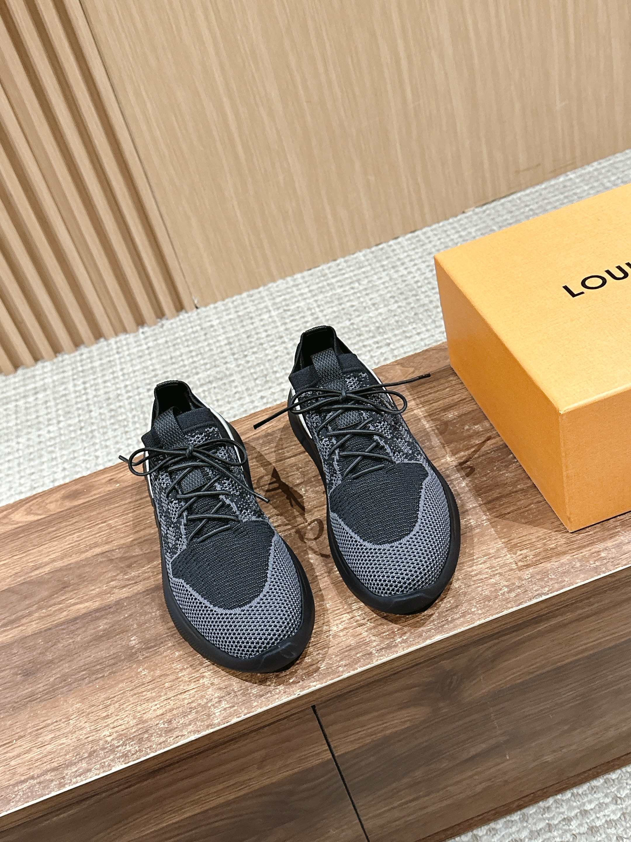 Black knit lace-up sneakers with round toe and textured rubber sole.