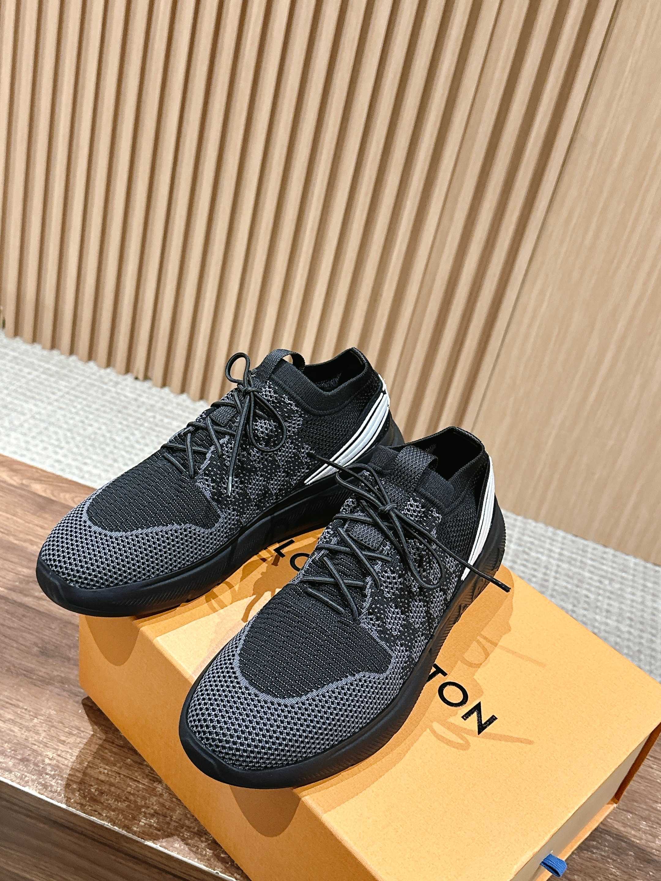Black knit lace-up sneakers with white side stripe and grippy rubber sole.