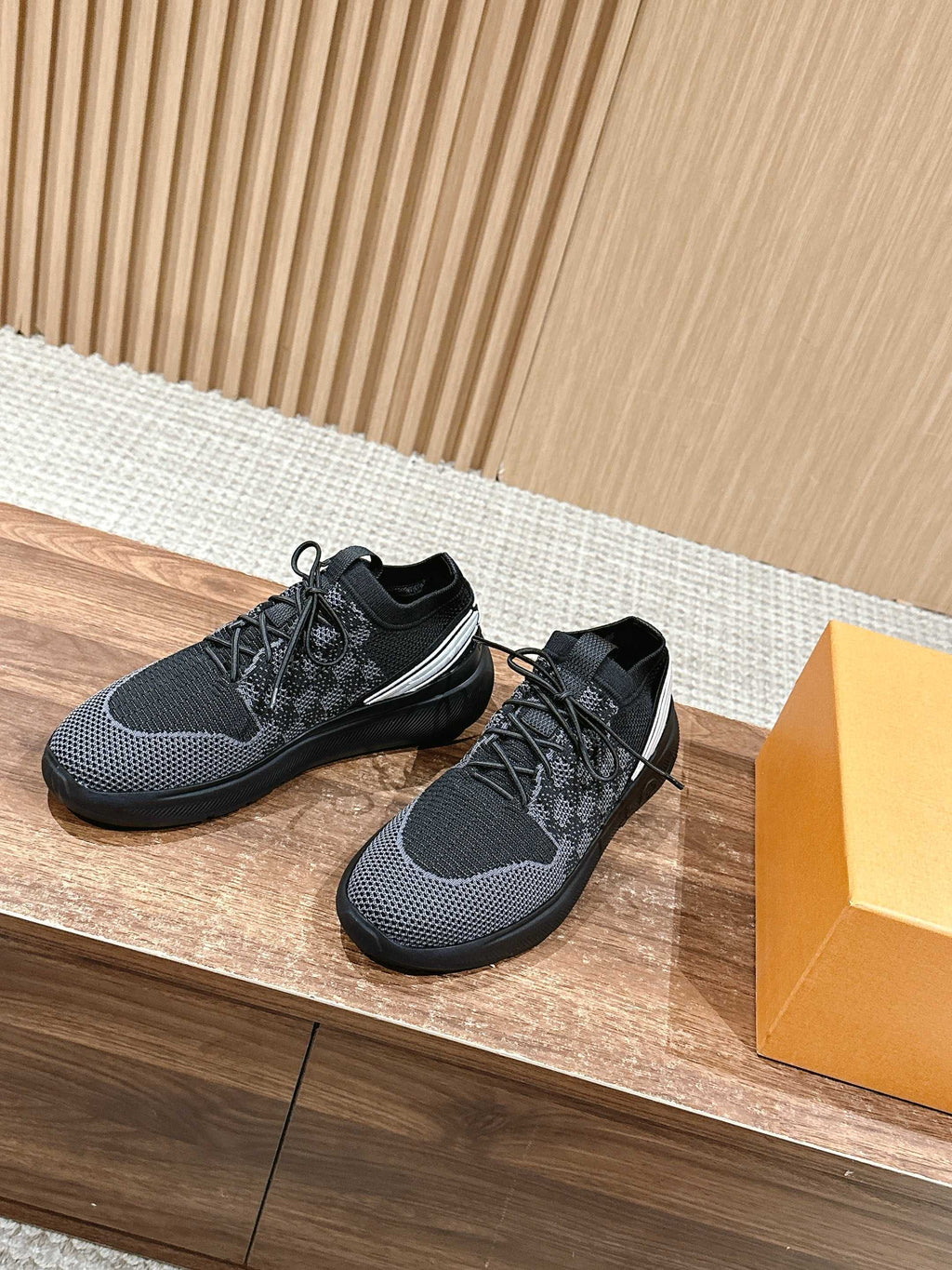 Black low-top lace-up sneakers with a white side stripe and rubber sole.