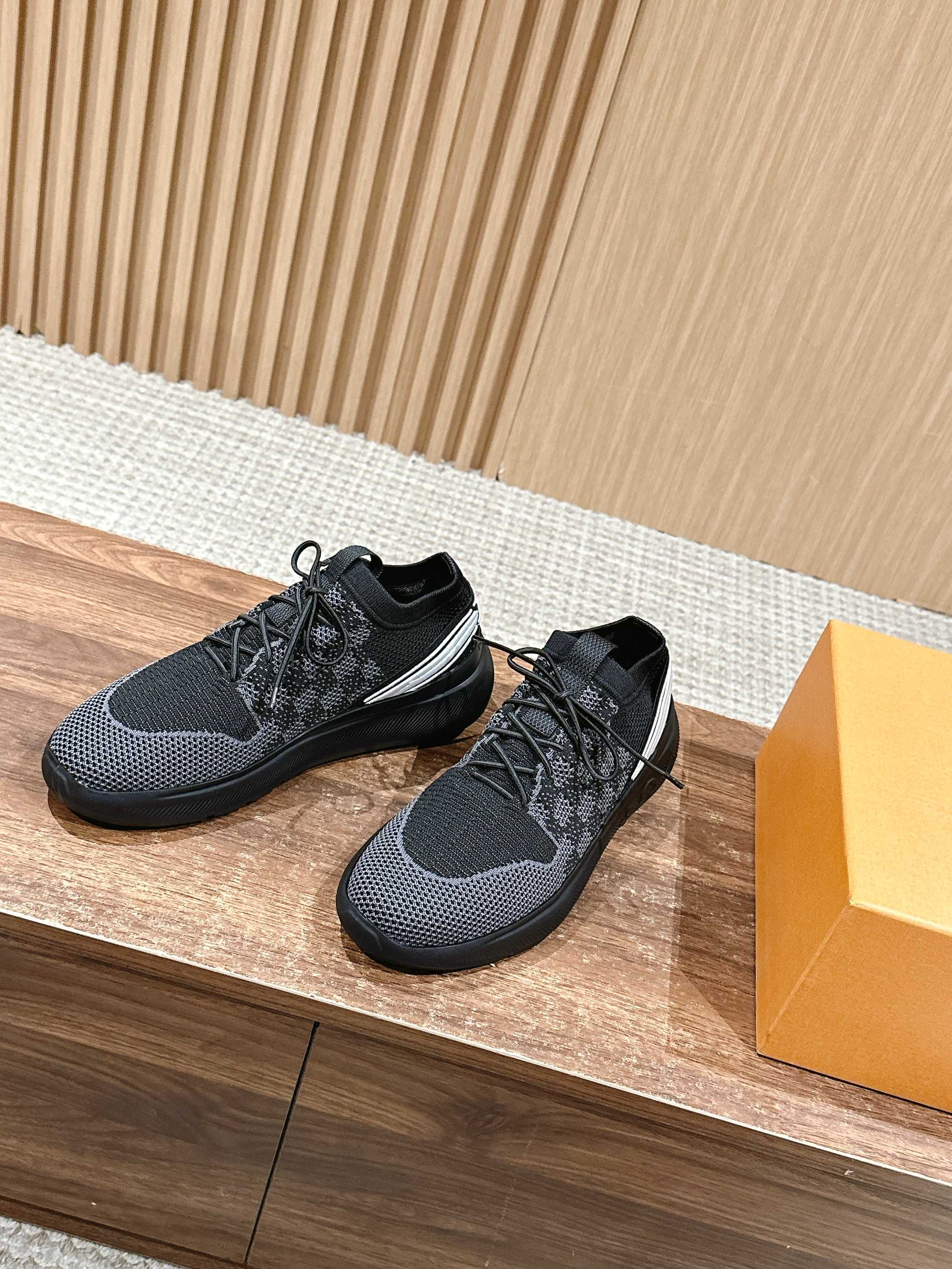 Black low-top lace-up sneakers with a white side stripe and rubber sole.