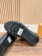 Black sneaker outsole with detailed tread pattern and logo patch near arch.