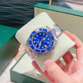 Rolex watch with blue dial and silver metal bracelet, resting on a white cushion