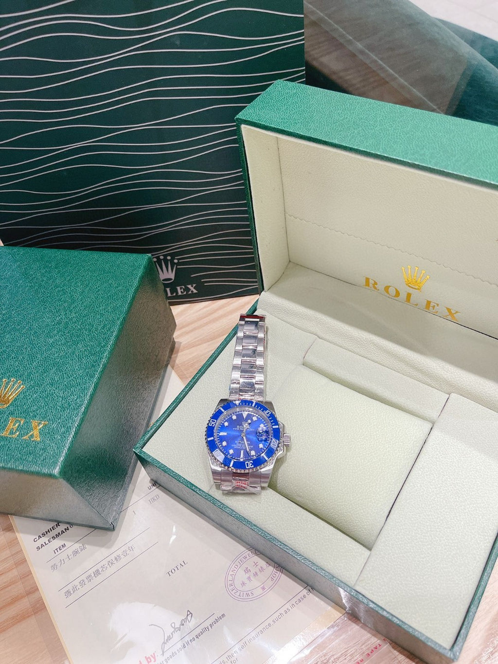 Rolex watch with blue dial and silver bracelet in open gift box with paperwork