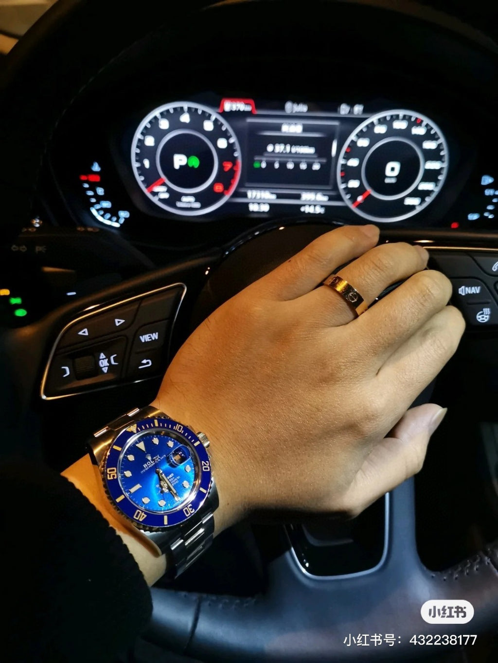 Rolex watch with blue dial on wrist, worn while driving in a car interior