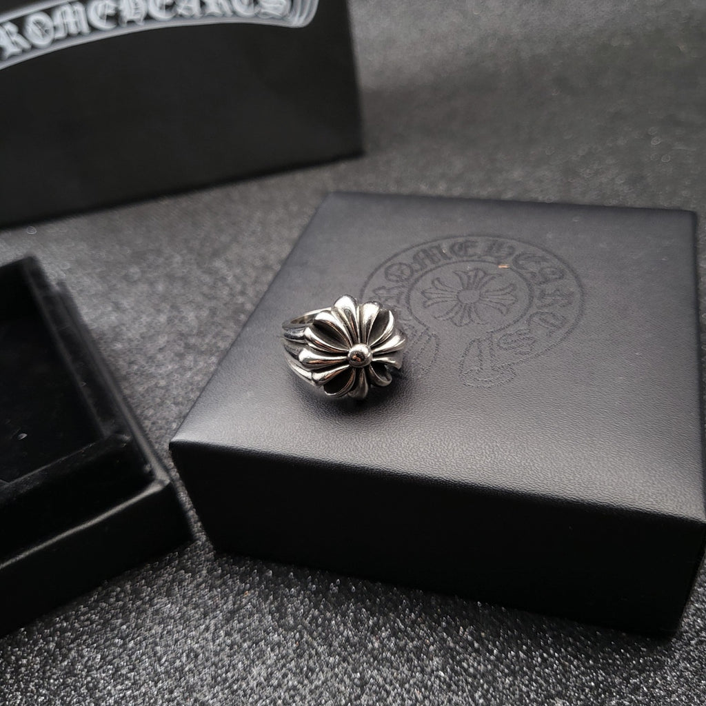 Silver-tone flower ring on gray jewelry box