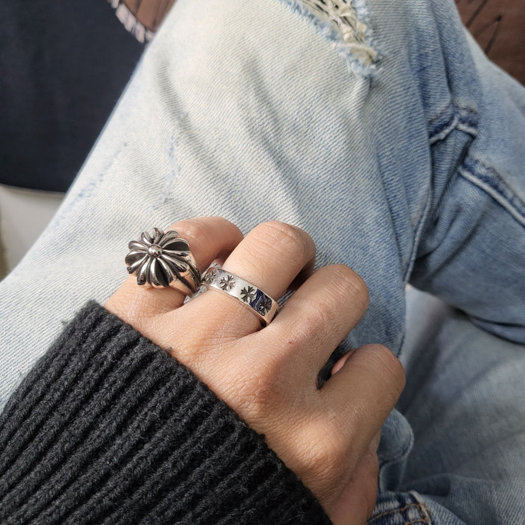 Silver-tone flower ring and matching band worn on hand