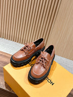 Tan leather lace-up shoes with black lug sole and lace-up front