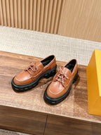 Tan leather lace-up shoes with black rubber sole and metal eyelets