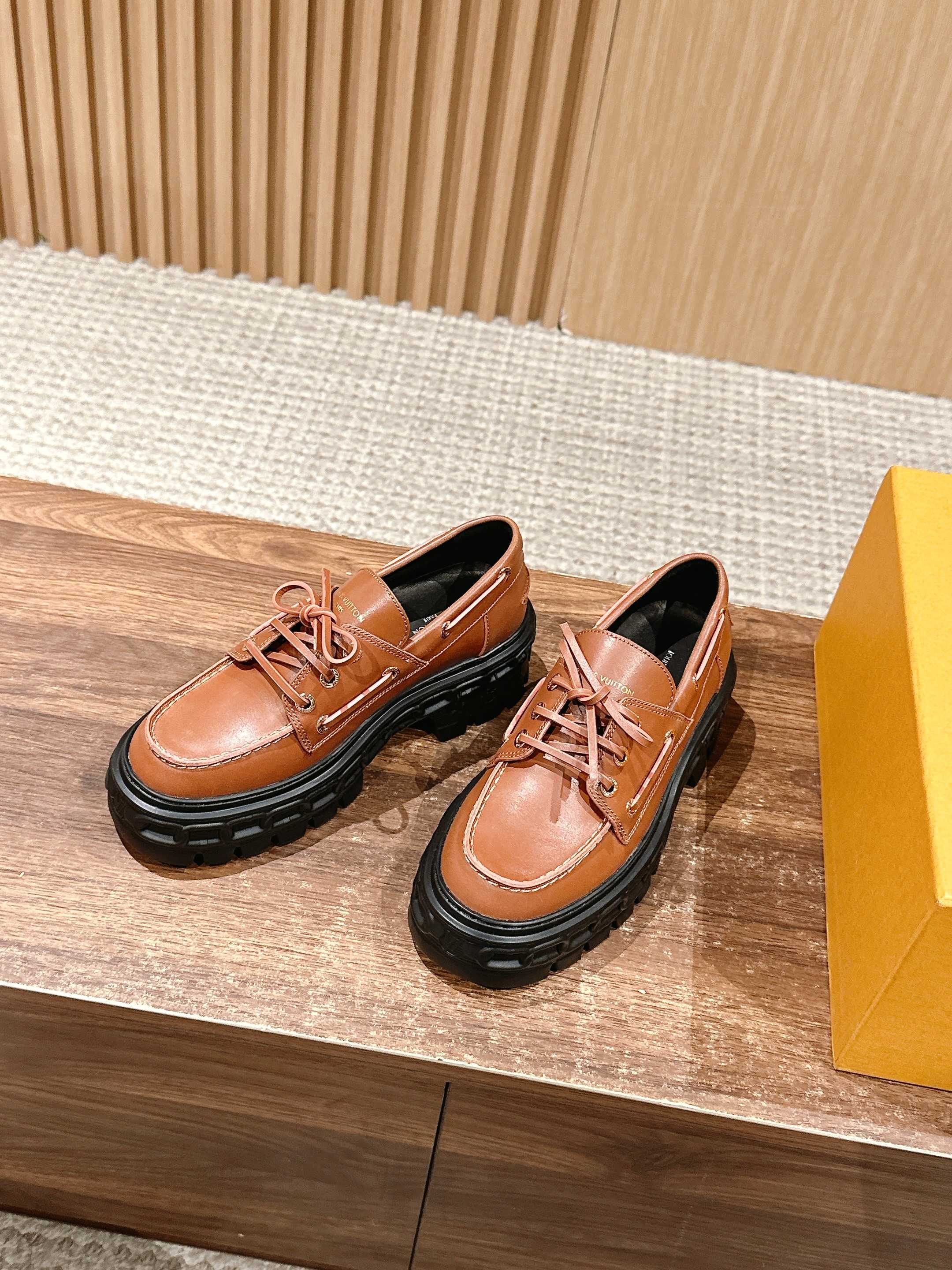 Tan leather lace-up shoes with black rubber sole and metal eyelets
