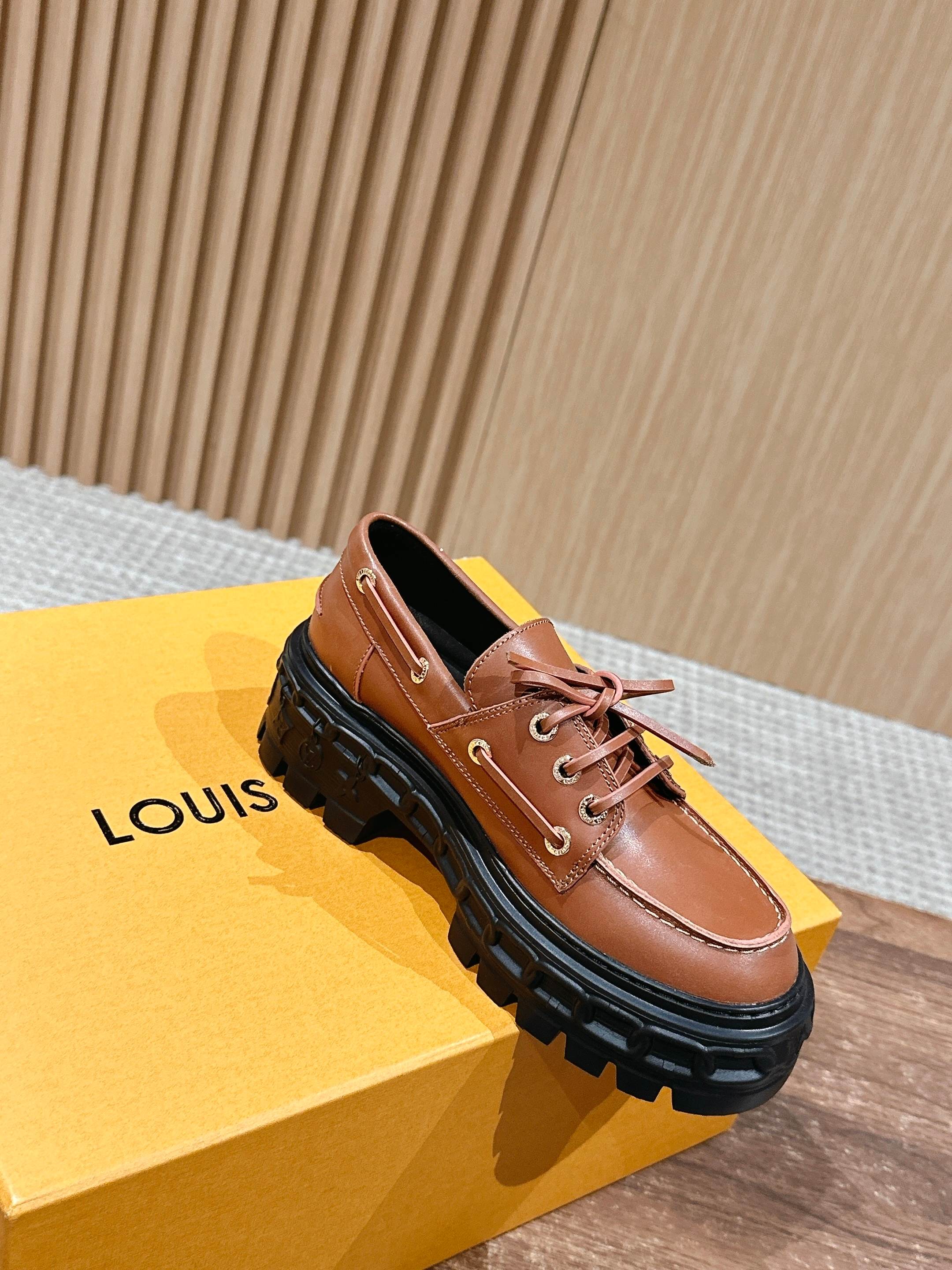 Tan leather lace-up shoes with thick black rubber sole and tied laces