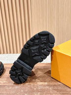 Black rubber outsole with raised star-like pattern, close-up on traction tread