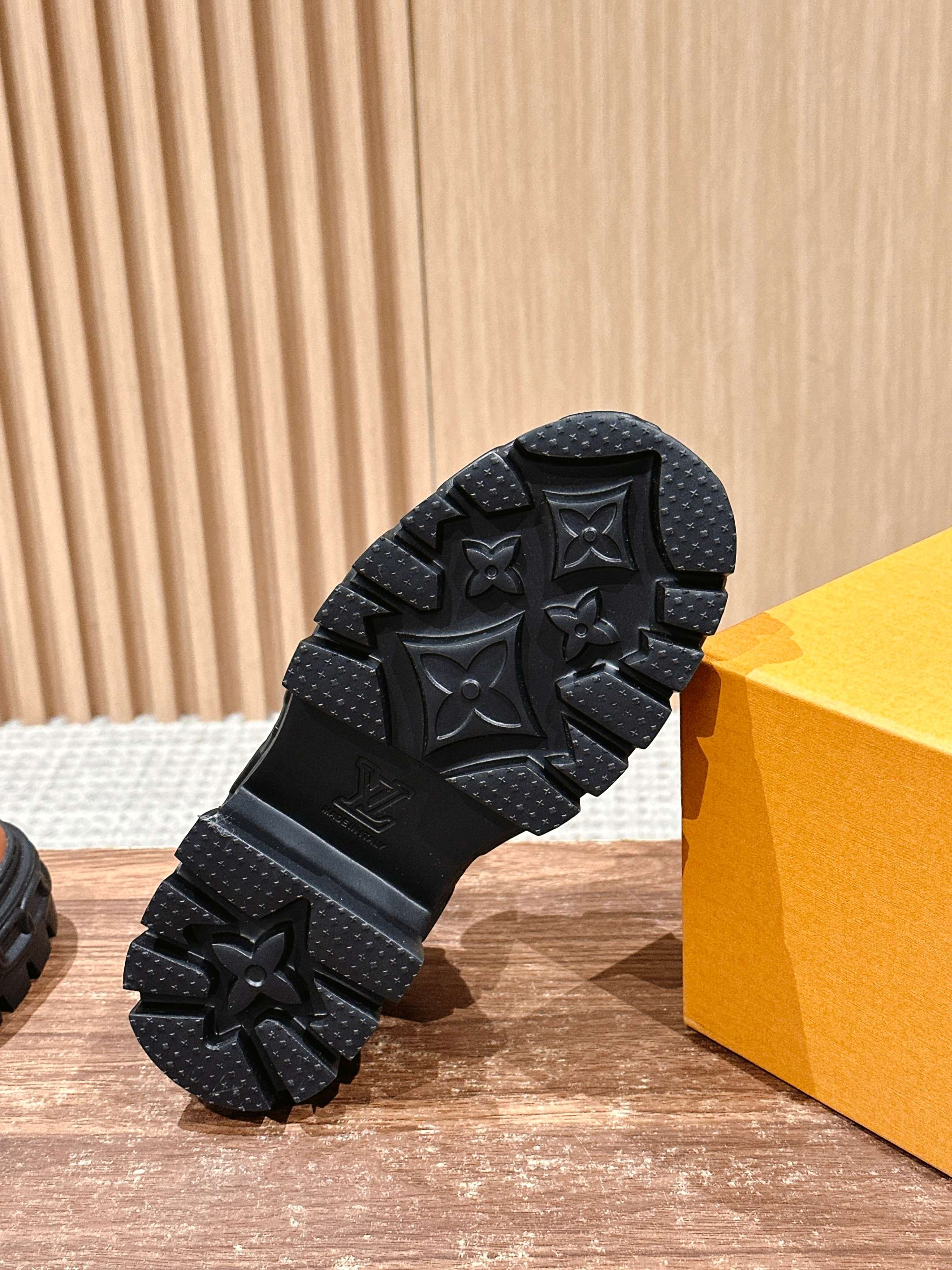Black rubber outsole with raised star-like pattern, close-up on traction tread