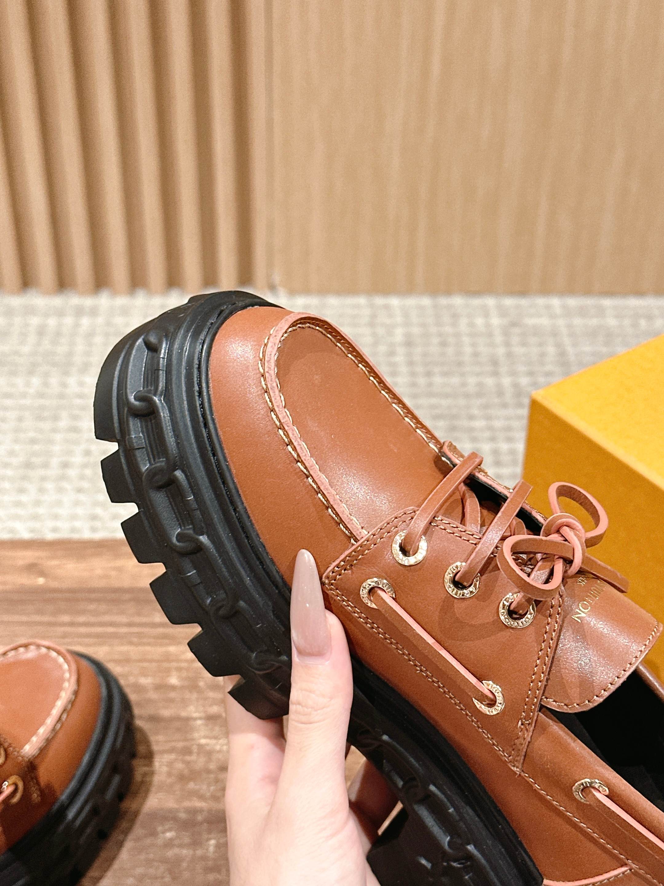 Tan leather lace-up shoe side view with black rubber sole and lace eyelets