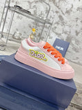 Pink and white low-top sneakers with orange laces and Dior logo on the side