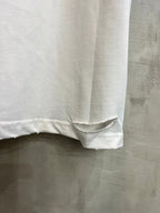 White T-shirt lower hem with distressed slit detail and stitched edge.